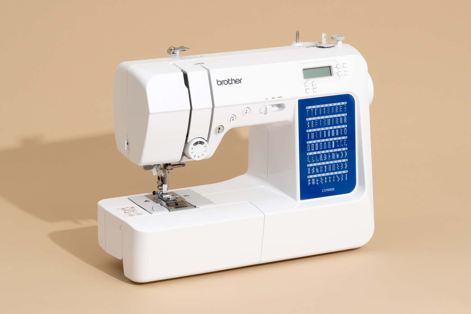 The open bobbin area of a sewing machine undergoing routine cleaning and maintenance.
